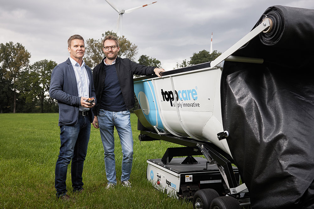 Simon Jegelka und Roland Draier von der topocare GmbH mit dem toporobo, der den Geotextilschlauch zum Hochwasserschutz verlegt.